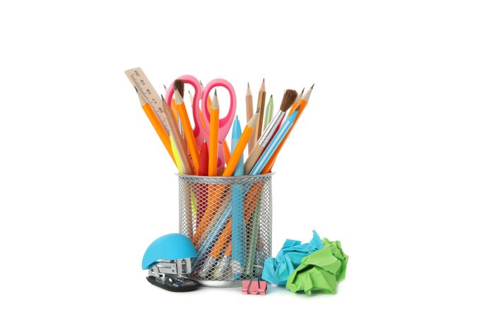 Pencils, scissors & assortment of stationary in container in plain space