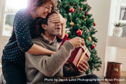 Young couple having fun celebrating Christmas with presents 0gXAQ3