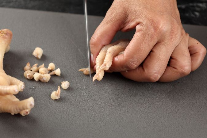 Close Up Female Hand Cutting Chicken Feet Nails