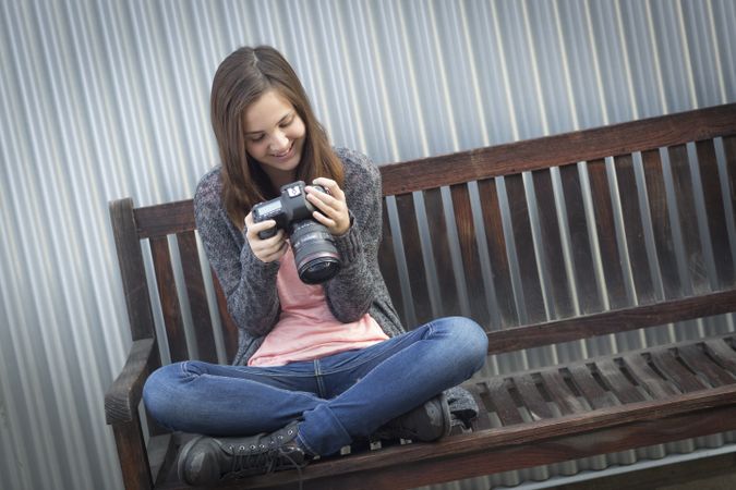 Young Girl Photographer Looking at Back of Camera