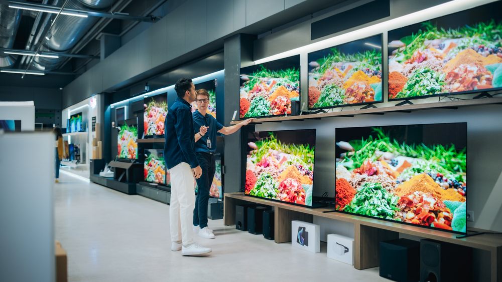 Client Shopping for a New Television Set in Modern Shop