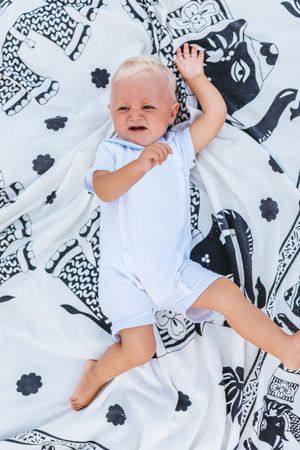 Top view of a blond baby crying
