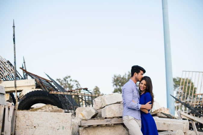 Loving couple hugging in abandoned building with metal fence