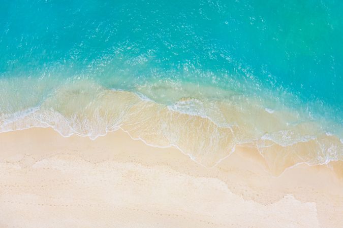 Aerial shot of waves coming up on a beautiful tropical beach
