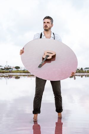 Man holding mirror with guitar reflection