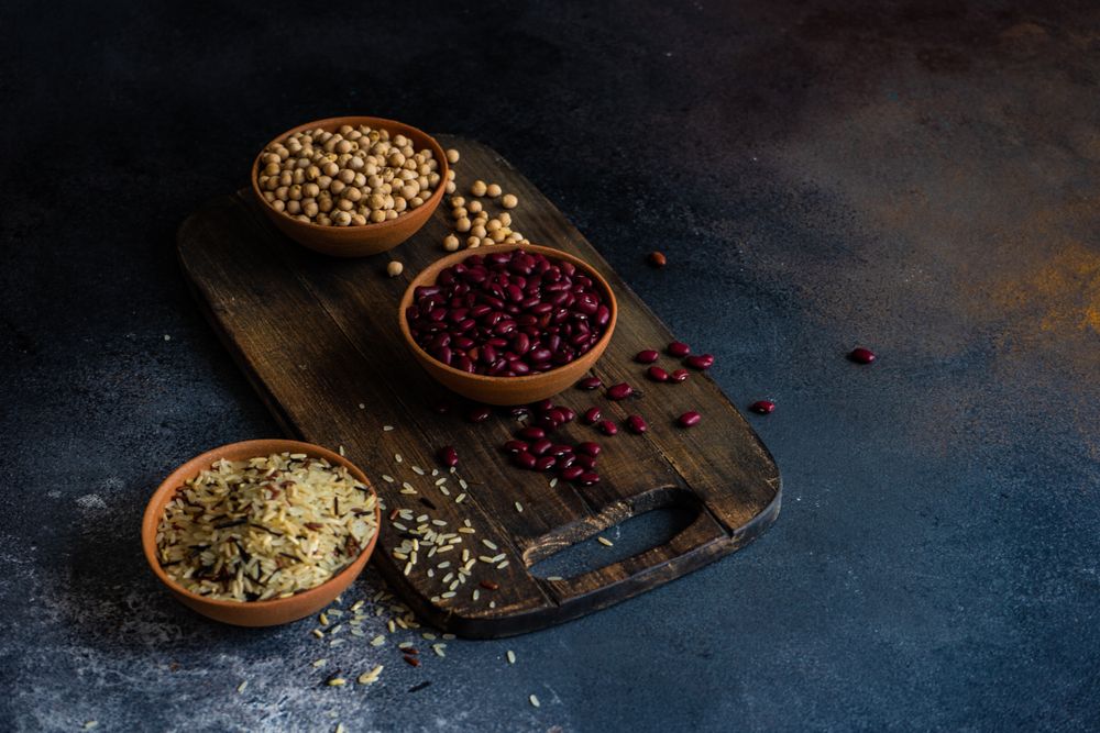 Dry beans and rice in bowls on counter with copy space