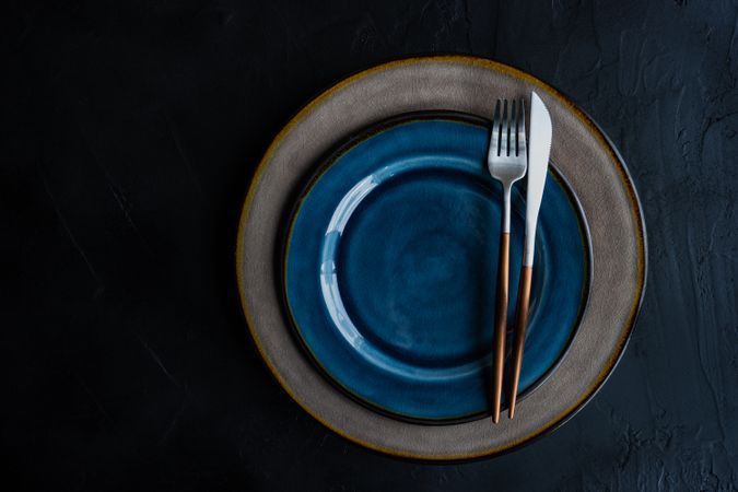 Rustic table setting with cutlery on ceramic navy plate and space for text