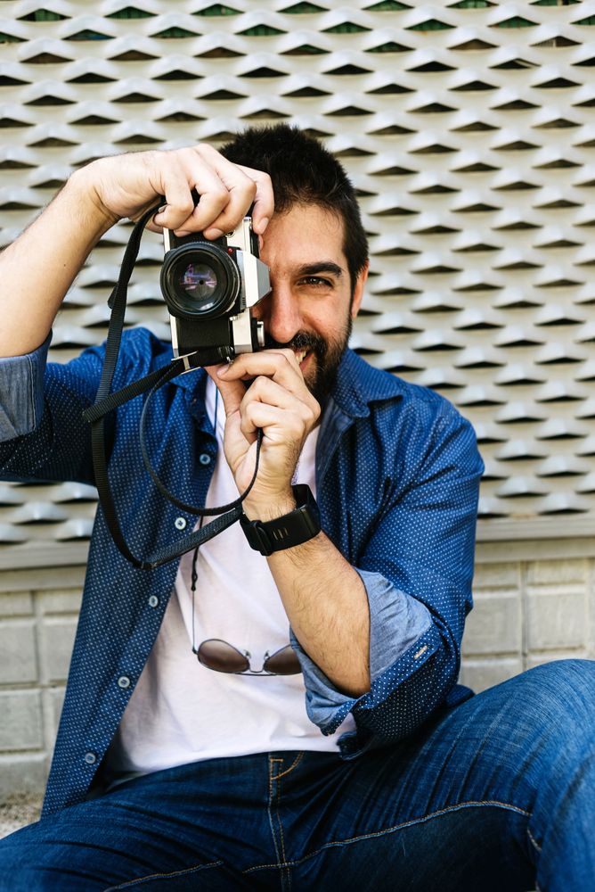 Smiling man in denim taking photo