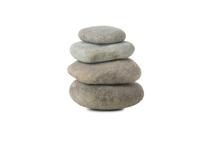 Four stones on top of each other, isolated on plain background