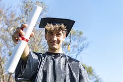 Happy graduated young man wearing a bachelor gown