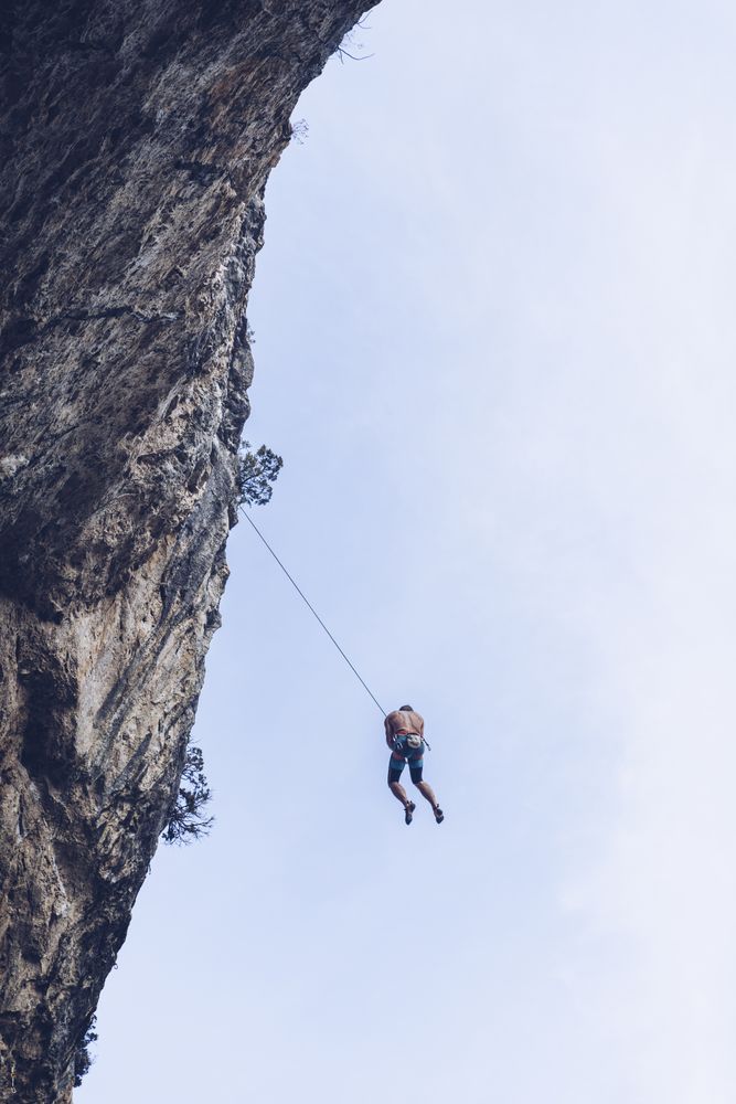 Anonymous climber handing on cliff