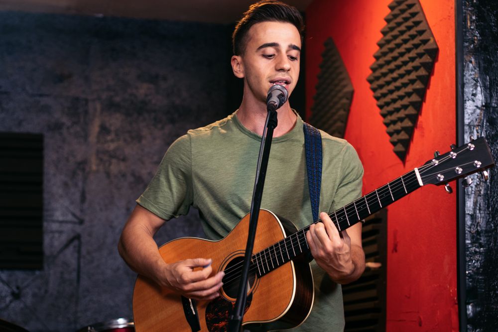 Musician practicing with the guitar in a recording and rehearsal room.