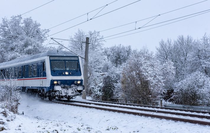 Passenger train traveling through snow, in nature, in Germany