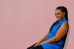 Confident female with bandage after immunization in pink studio shoot, copy space