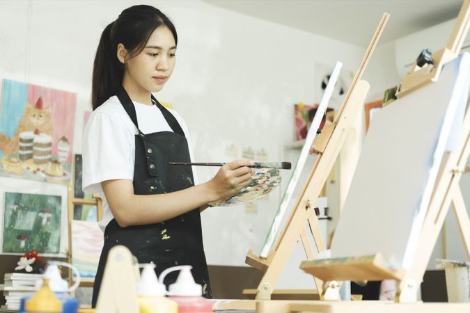 Crafting Inspiration: Female Artist Sketching and Painting in Workshop