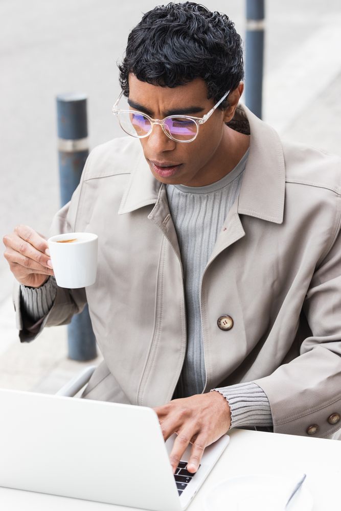 Focused man using laptop and drinking coffee