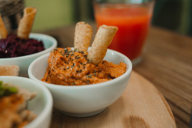 Different tasty sauces on round wooden stand
