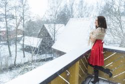 Woman in red dress under snowfall