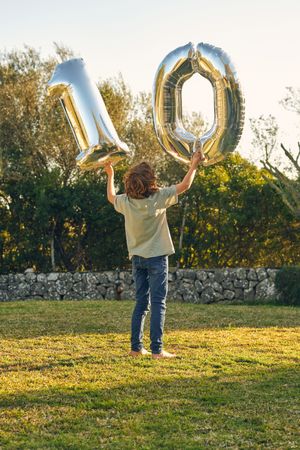 Anonymous boy with number ten made out of balloons