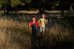 Cheerful siblings running in nature