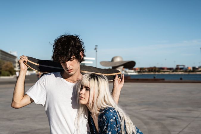 Trendy in love couple hugging on street