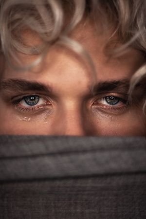 Young man's mischievous blue eyes
