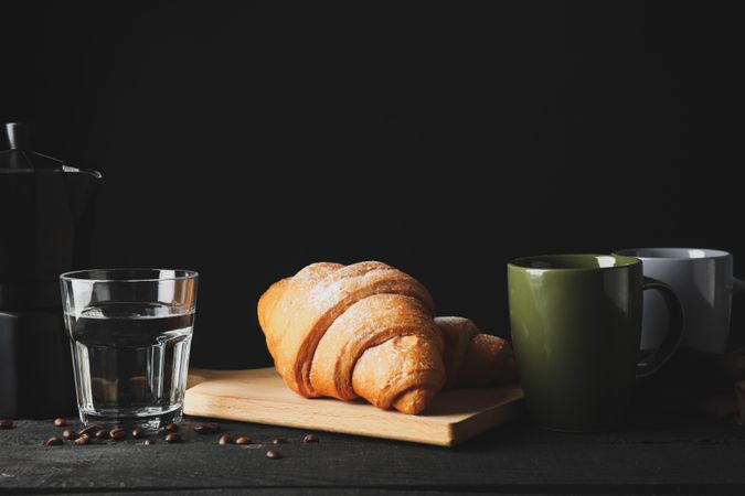 Composition with croissants on wooden breadboard, with space for text