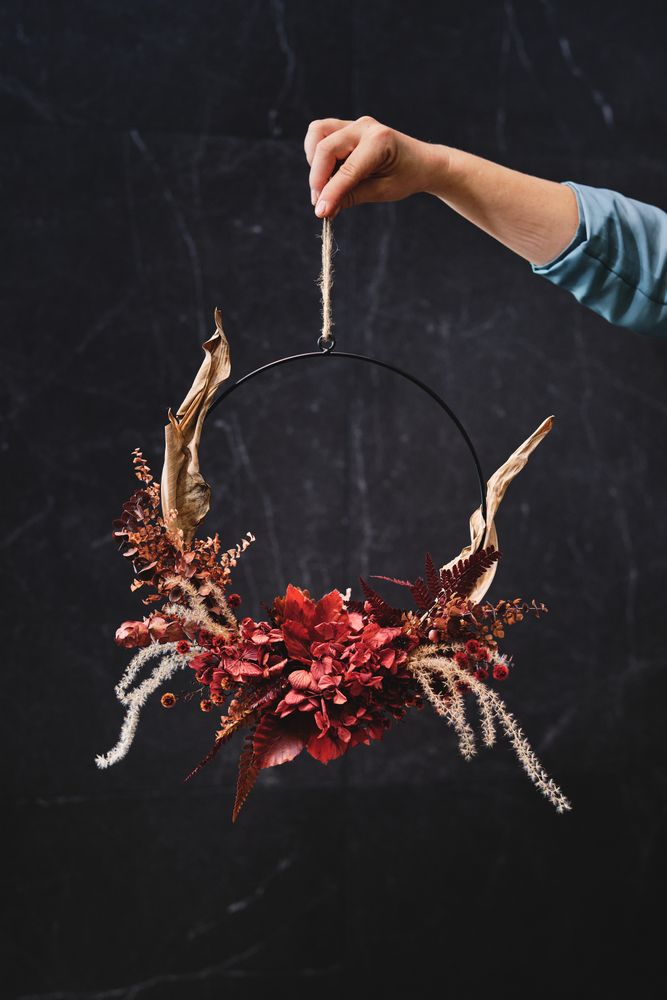 Crop person with dried floral wreath
