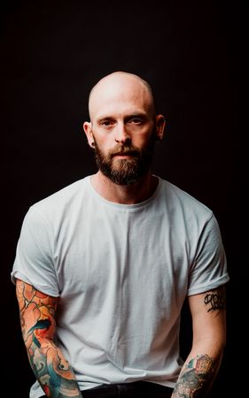 Young bald guy showing tattoos