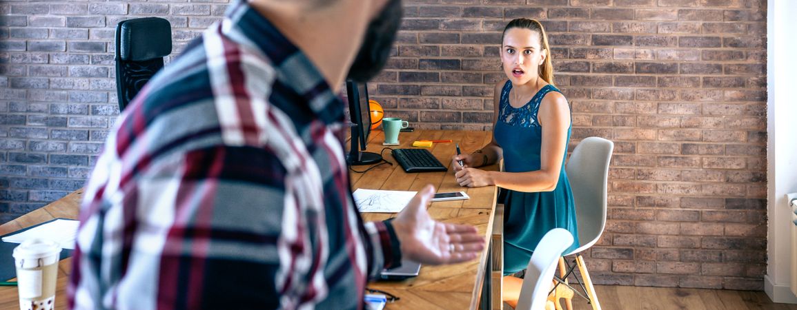 Woman shocked by what her coworker is telling