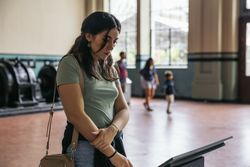 A woman stands reading an informational sign in a museum