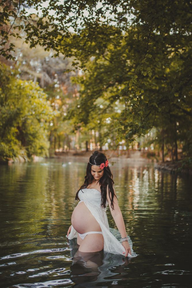 Pregnant woman standing in lake water