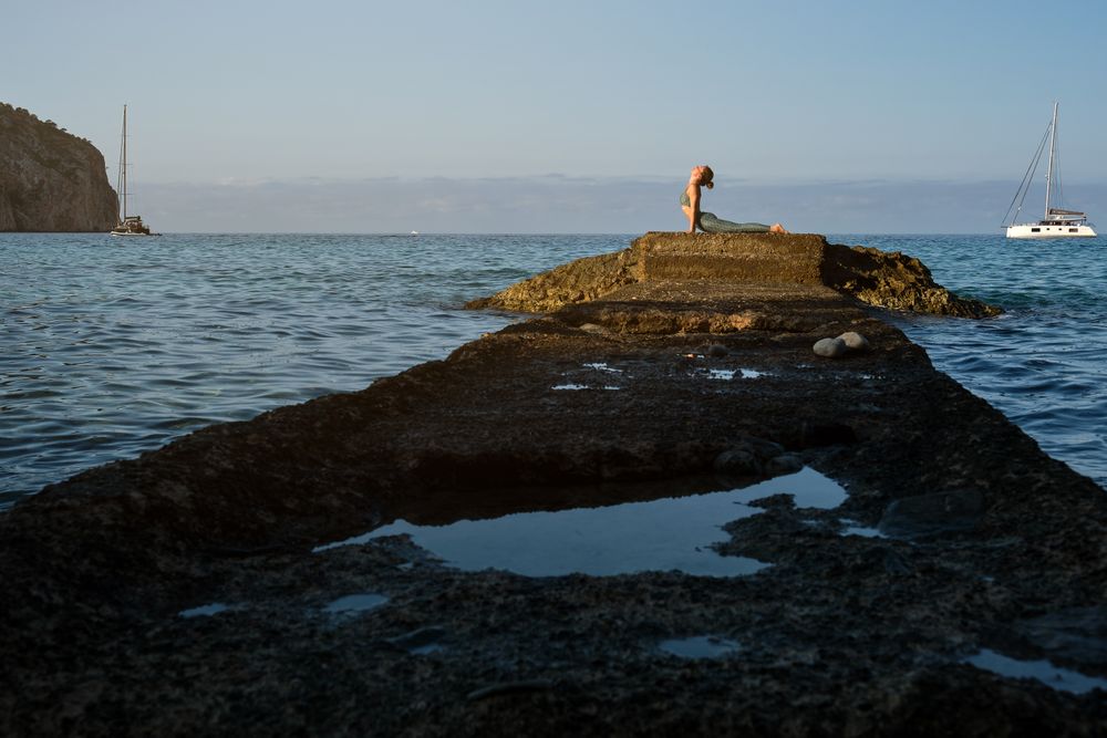 Young woman practicing yoga at seaside