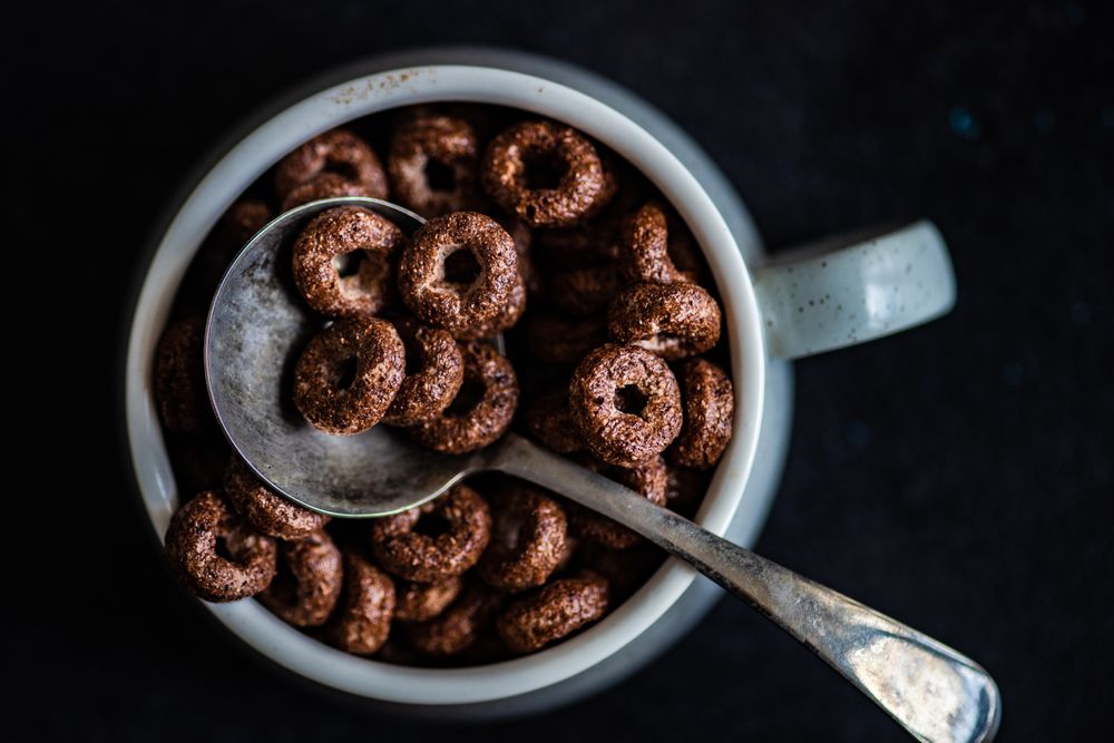 Traditional breakfast with chocolate cereal in mug with spoon