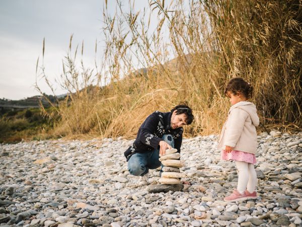 Father and little daughter playing on beach