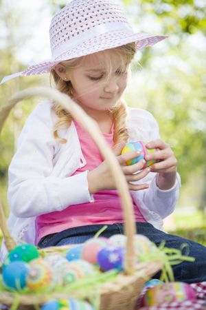 Cute Young Girl Wearing Hat Enjoys Her Easter Eggs