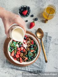 Person pouring sauce inside bowl of cereal and fruits 5wkyZ5