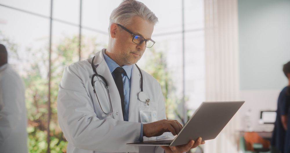 Portrait of a Medical Health Care Professional Using a Laptop Computer in Hospital Office.
