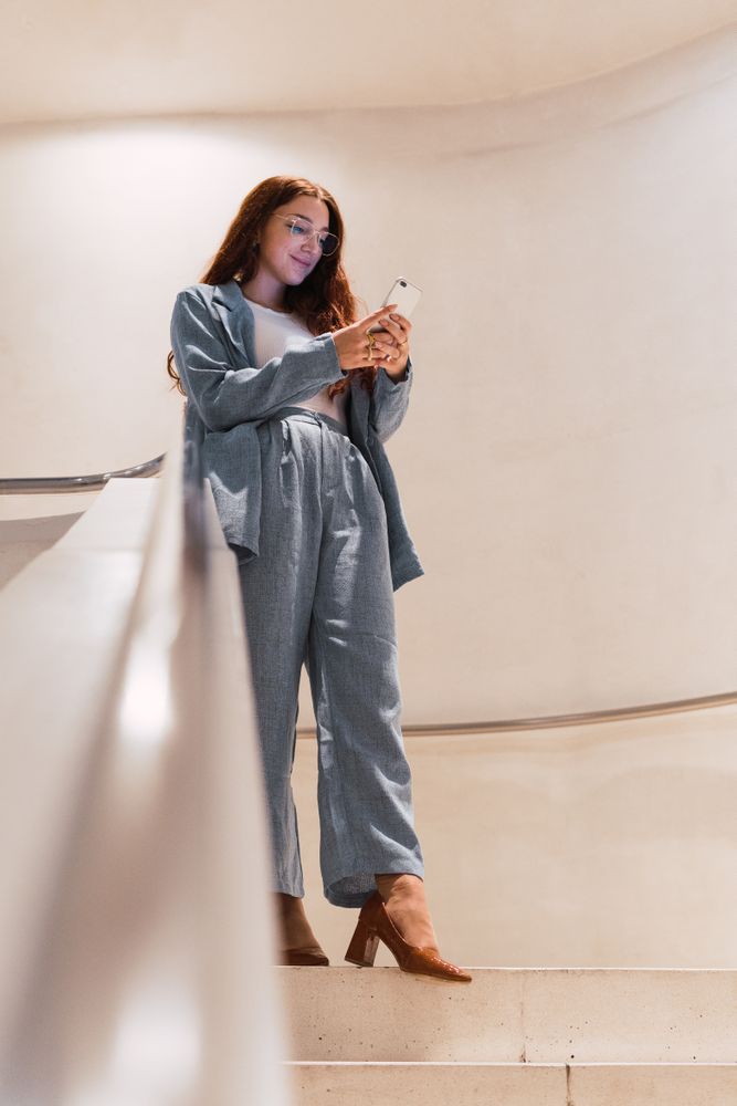 Woman browsing smartphone on staircase
