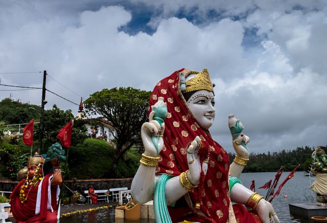 Red veiled Laksmi statue outside on cloudy day