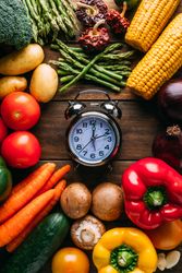Vegetables lying around alarm clock