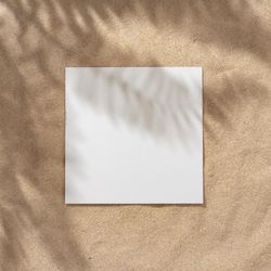 Sand with palm leaf shadows and central square