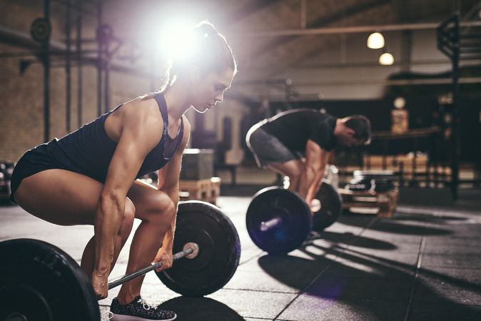 Young couple doing deadlift exercise together