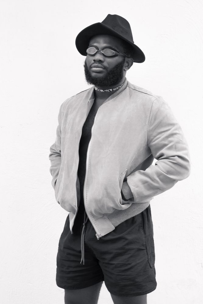 Grayscale photography of man with both hands on pocket