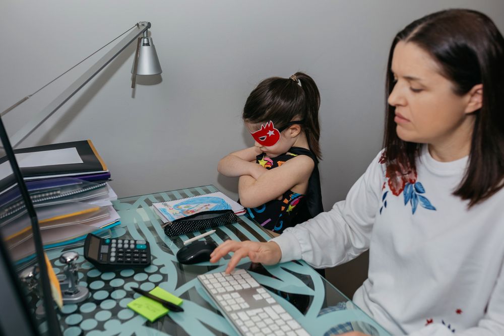 Woman teleworking with her angry daughter