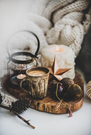Coffee, candles, festive decorations against woolen blanket
