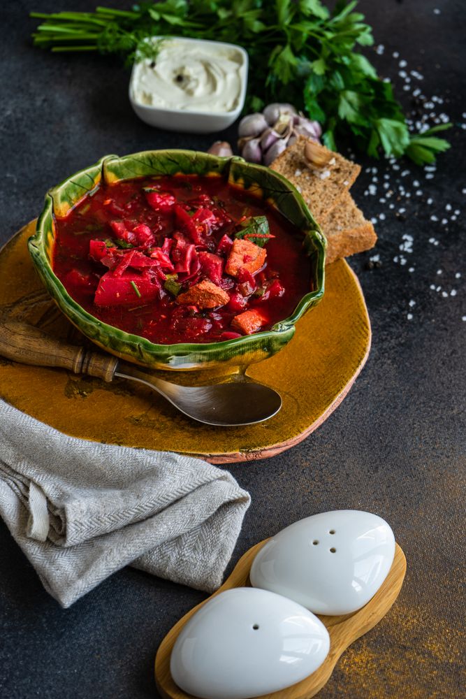 Ukrainian beetroot soup borscht in green bowl with crackers