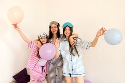 Family having fun with balloons in striped pajamas at home.