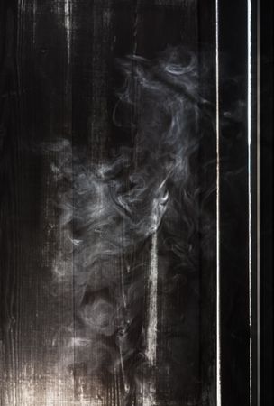 Smoke next to a wooden wall