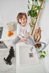 Smiling boy cleaning hands with soap on counter